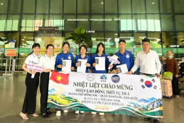 Nhóm cầm hộ chiếu và băng rôn chào mừng đoàn lao động E8-1 ở sân bay – Tiễn đoàn E8-1 lên đường