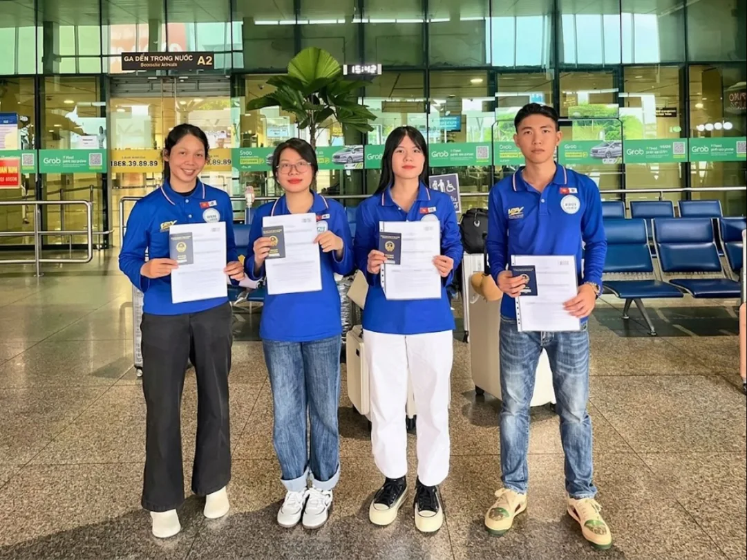 Workers holding passports at the airport before departing to work abroad with KPV