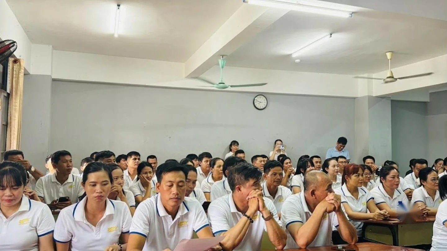 Lớp học đông người mặc áo polo trắng ngồi nghe giảng, có quạt trần – giá trị KPV Group theo đuổi