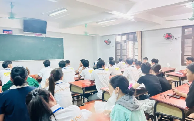 Học viên áo đồng phục trắng có chữ KPV ngồi trong lớp nhìn lên bảng xanh – lớp học tiếng Nhật tại KPV Đồng Nai