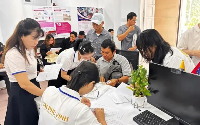 Nhân viên áo KPV hướng dẫn mọi người điền hồ sơ tại bàn trong văn phòng – không gian học tập, tư vấn tại KPV