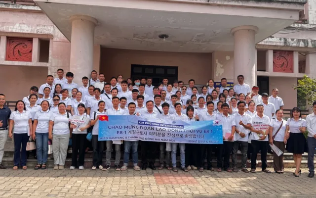 Ảnh tập thể đông người áo trắng cầm băng rôn chào mừng đoàn E8-1 trước tòa nhà – cơ hội du học, việc làm nhờ tiếng Hàn