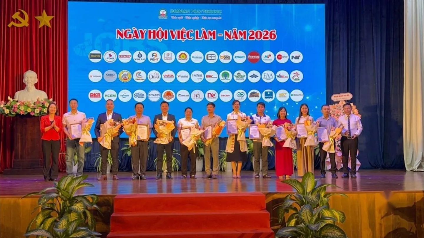 Đại biểu cầm hoa đứng trên sân khấu Ngày hội việc làm năm 2026 – workshop hướng nghiệp tại trường cùng KPV