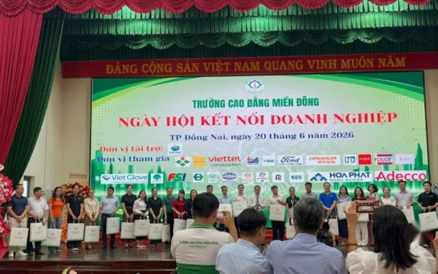 Đại diện doanh nghiệp cầm túi quà đứng trên sân khấu Ngày hội kết nối doanh nghiệp của Trường Cao đẳng Miền Đông, 20/06/2026