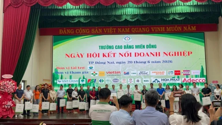 Đại diện doanh nghiệp cầm túi quà đứng trên sân khấu Ngày hội kết nối doanh nghiệp của Trường Cao đẳng Miền Đông, 20/06/2026