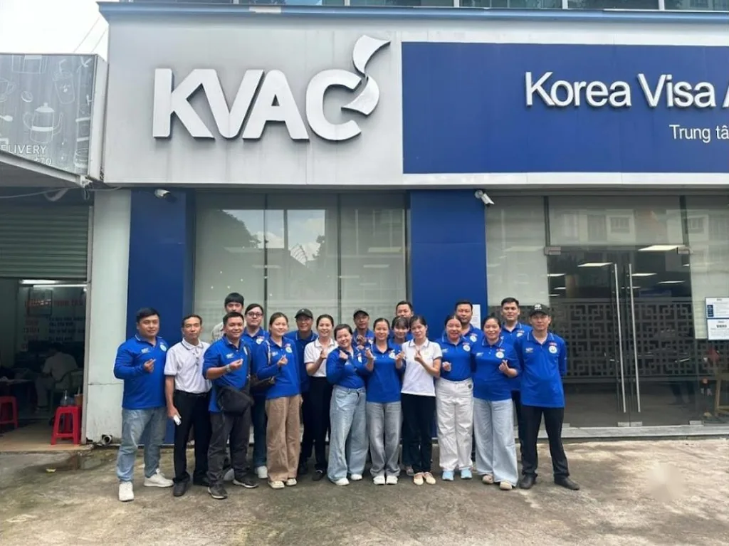 Nhóm mặc áo xanh chụp ảnh trước cửa Korea Visa Application Center (KVAC) – tư vấn du học Hàn, Nhật, Đức cùng KPV